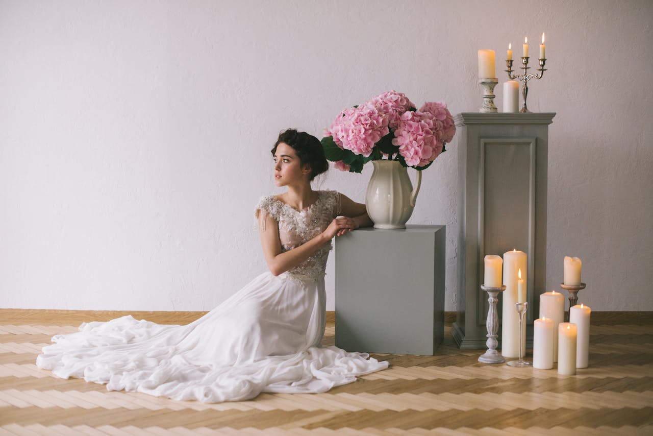 Woman in White Wedding Dress Sitting on the Floor Near Bouquet of Flowers